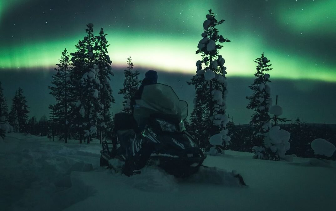 Northern lights by Snowmobiles in Ylläs