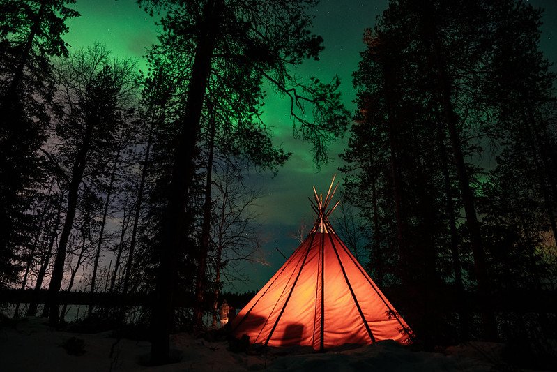tipee in the forest with northern lights